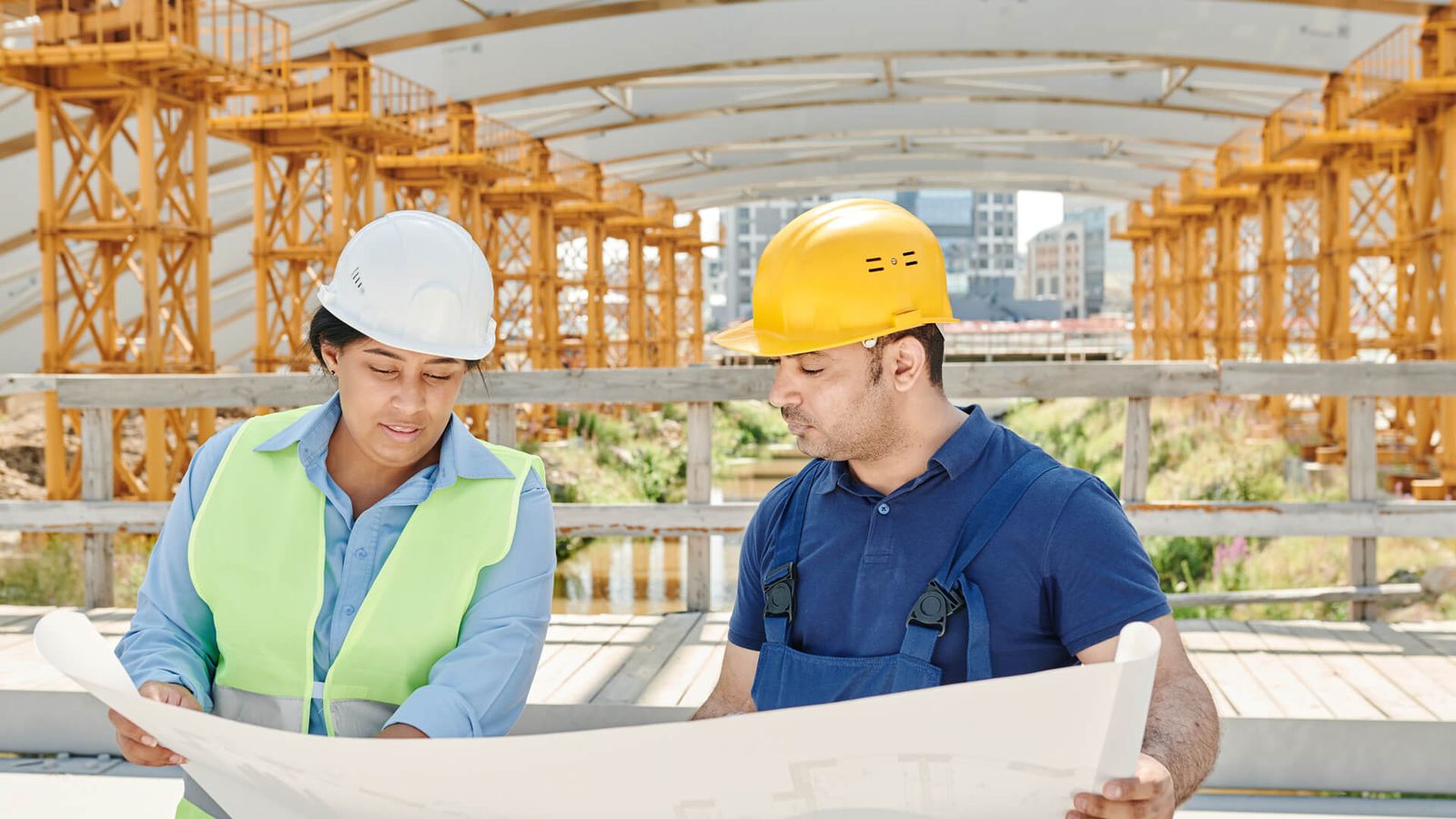 Zwei Bauleute besprechen einen Bauplan auf der Baustelle