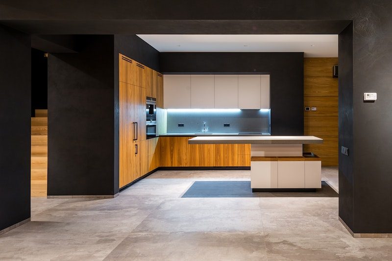Modern ausgebaute Wohnküche mit dunklen Wänden und Holzfronten